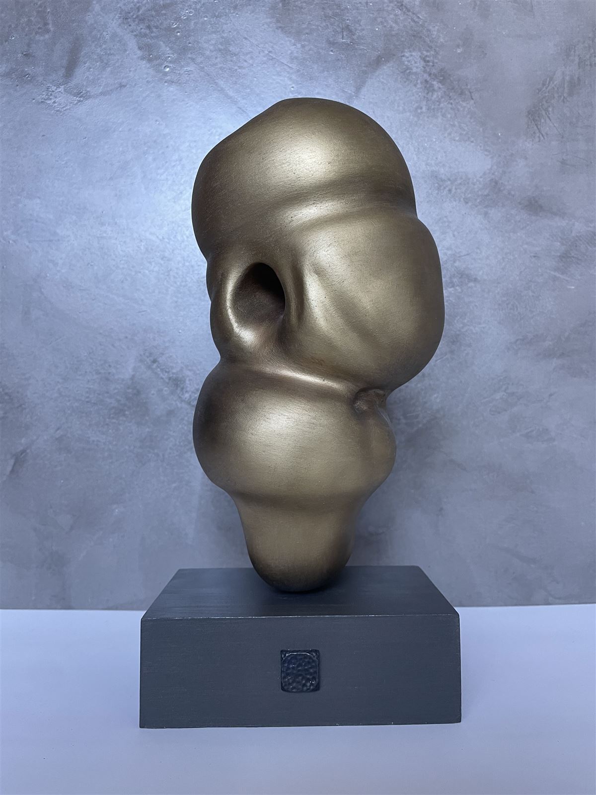 Traverse — brass-toned abstract sculpture of stacked, rounded volumes
