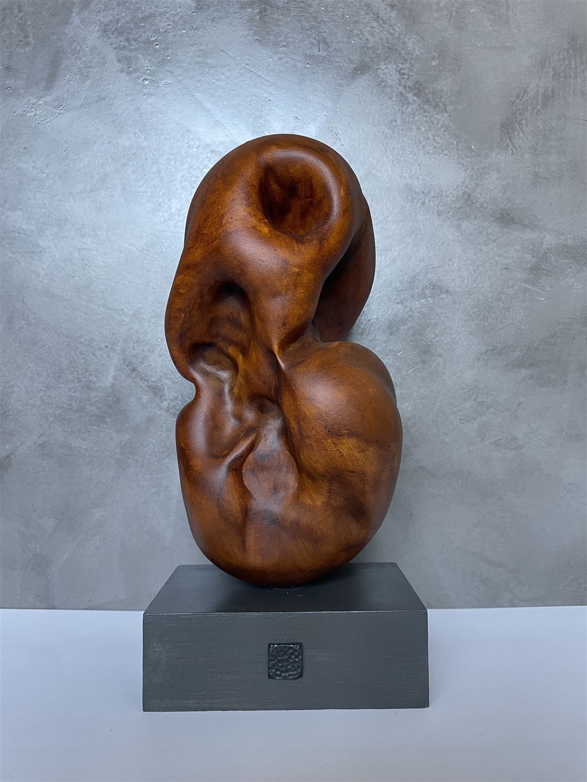 Windows of Turmoil — warm wood-toned abstract sculpture with twisting, folded surfaces